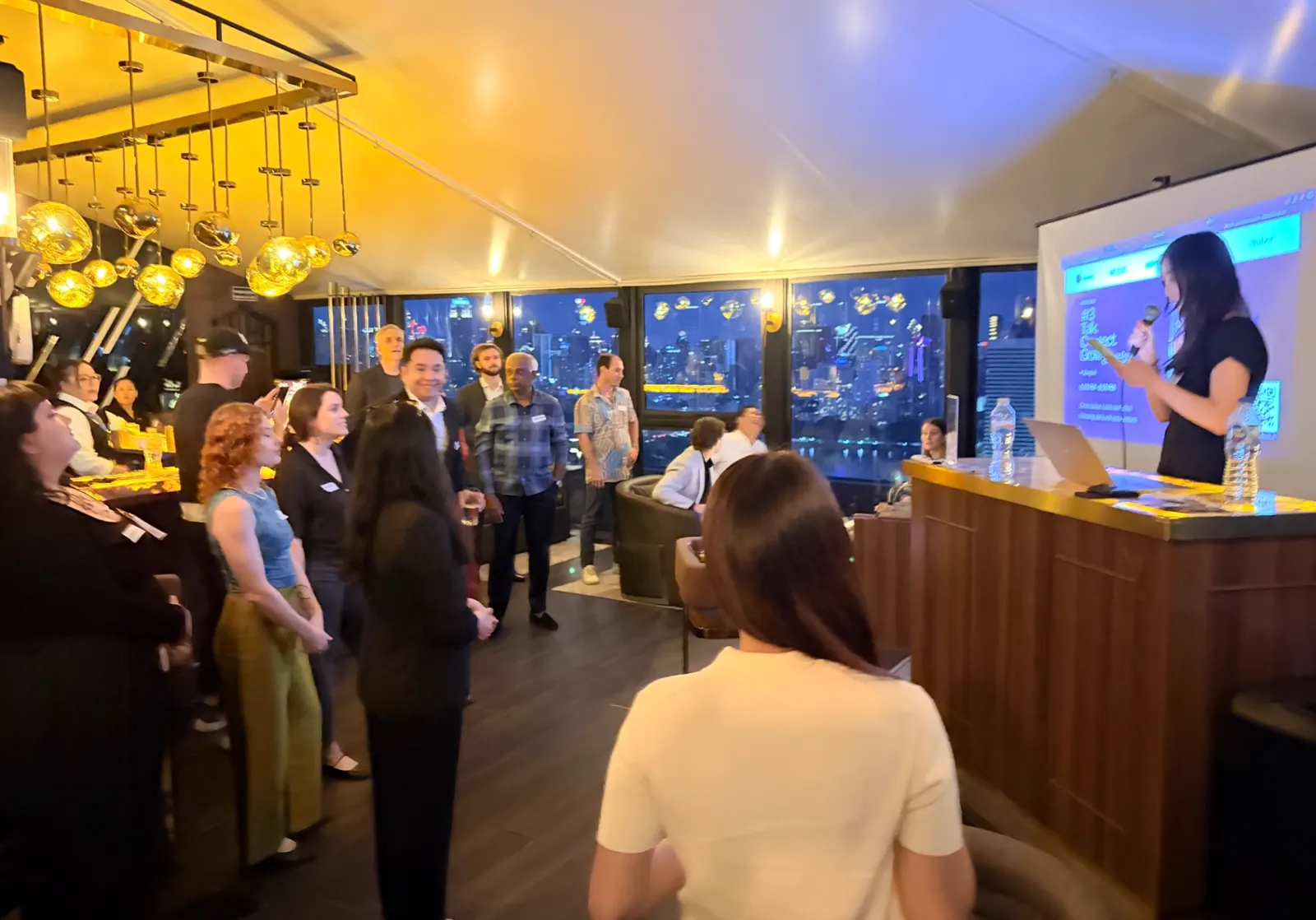 Members mingling at a rooftop networking night in Bangkok