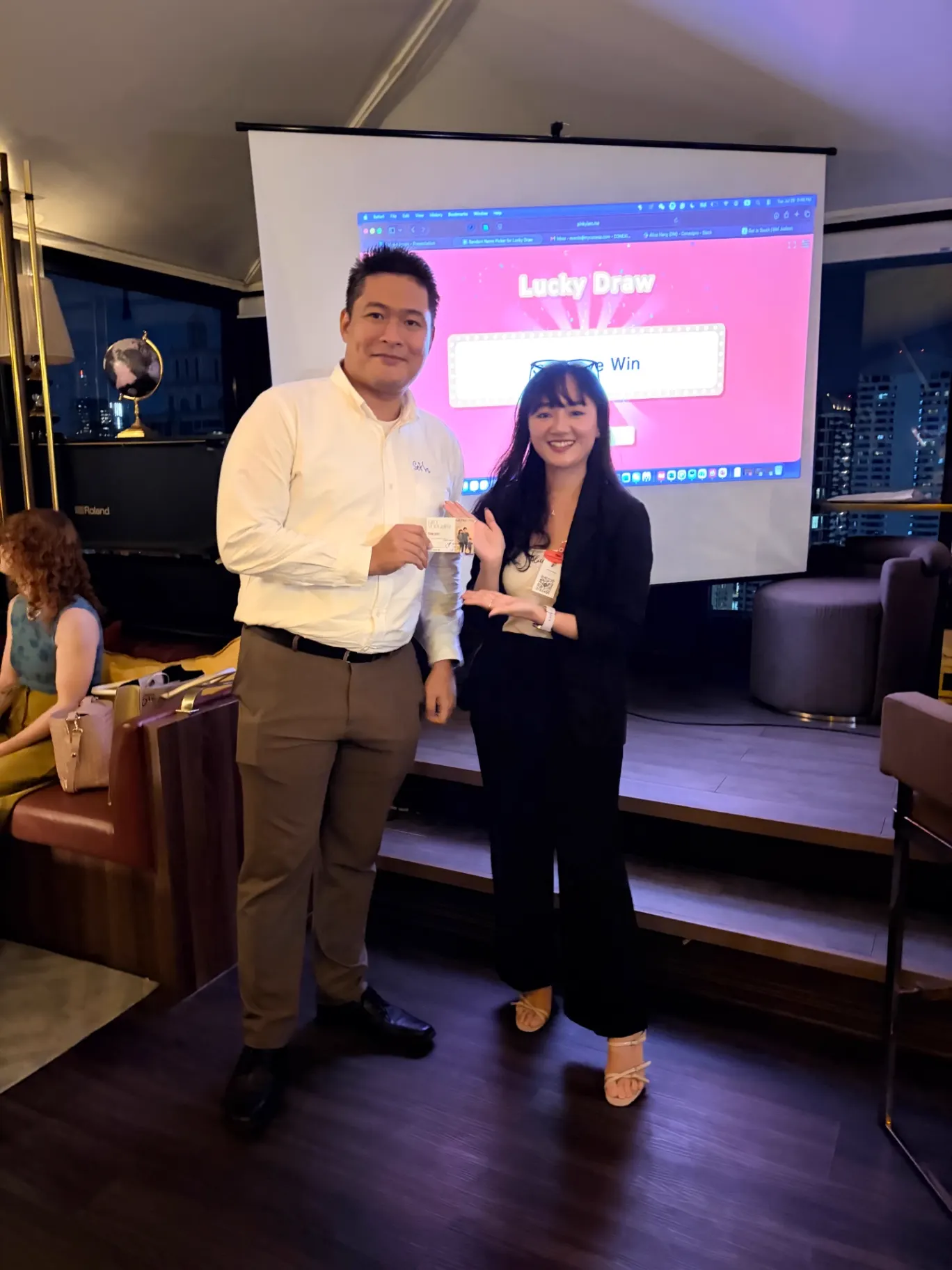 Two members holding a prize during an event lucky draw